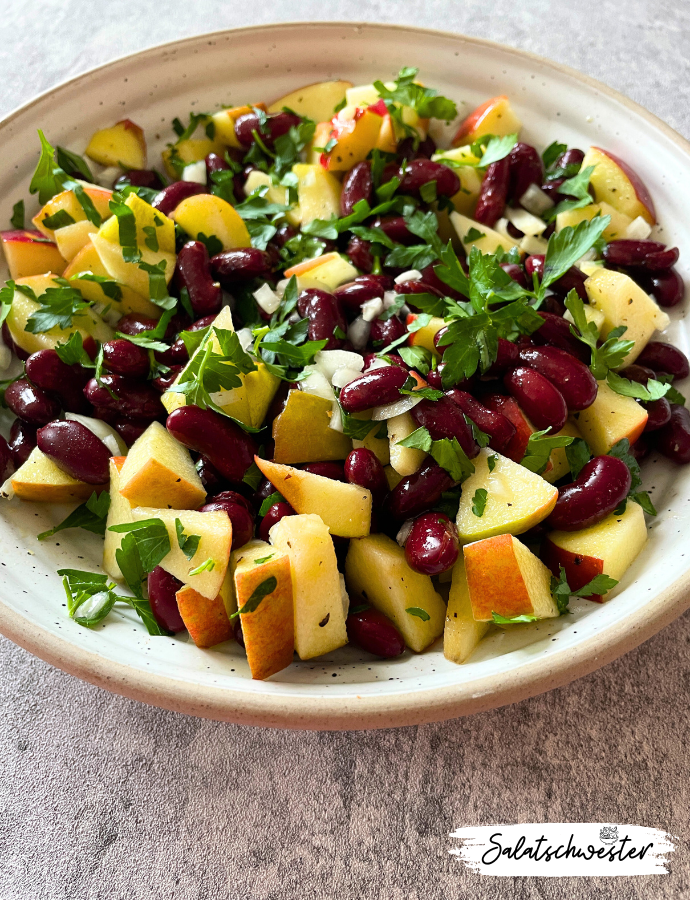 Eine köstliche Fusion aus süß und herzhaft: Mein veganer Salat mit Zwiebeln und Petersilie vereint die süße Frische von Äpfeln mit der herzhaften Note von Kidneybohnen zu einer köstlichen Fusion, die deinen Gaumen verwöhnen wird. Die fein gehackte Petersilie verleiht dem Salat eine frische und würzige Note, die perfekt mit den anderen Zutaten harmoniert. 