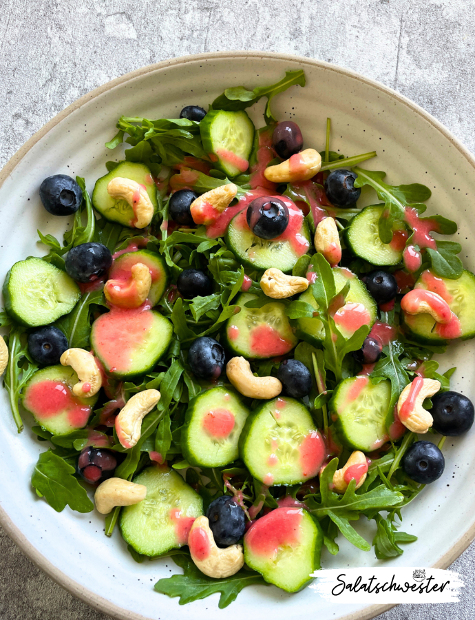 Salat mit Rucola, Heidelbeeren, Gurken, Cashewkernen und Himbeervinaigrette