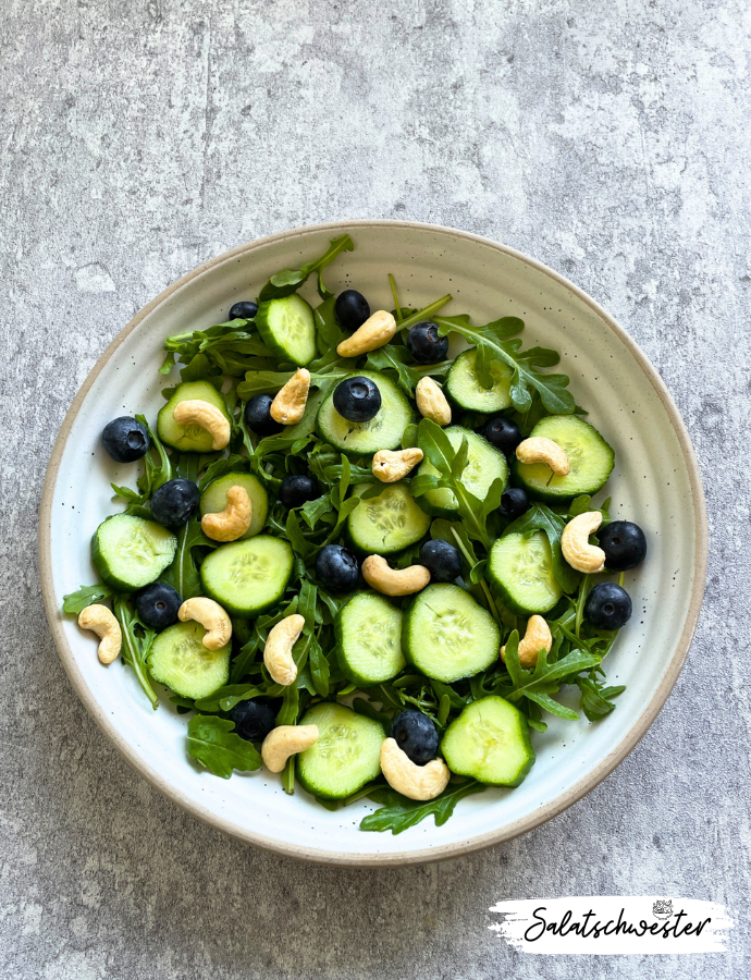 Wenn du auf der Suche nach einem frischen und gesunden Salat bist, der sich schnell zubereiten lässt, dann ist mein Rezept für Salat mit Rucola, Heidelbeeren, Gurken, Cashewkernen und Himbeervinaigrette genau das Richtige für dich. Dieser vegane Salat vereint fruchtige und nussige Aromen und wird durch das Himbeer-Dressing perfekt abgerundet. Probiere es aus und entdecke eine neue Lieblingskombination für deinen nächsten herbstsalat.