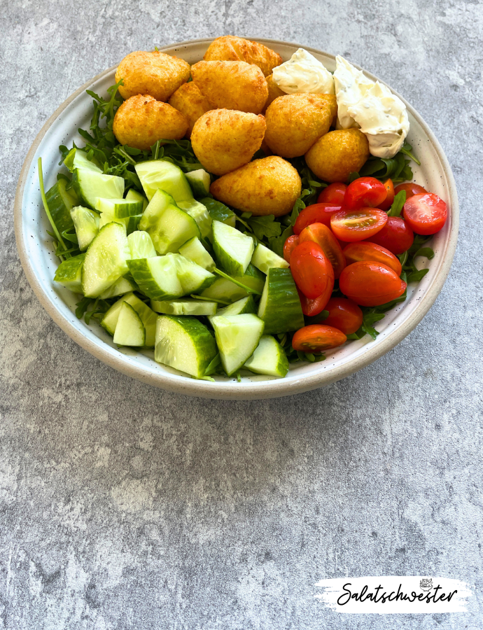 Für alle, die Lust auf Abwechslung haben: Die Salatbowl mit Kroketten und Frischkäse vereint knackiges Gemüse, cremigen Frischkäse und krosse Kroketten zu einer überraschenden Kombination. Diese vegetarische Bowl ist perfekt als herzhafter Herbst- oder Wintersalat und bietet eine besondere, schnelle Option für alle, die neue Ideen für ihre Salatrezepte suchen.