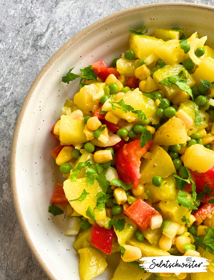 Hausgemachter Kartoffelsalat mit Mais und Erbsen, angerichtet als gesunde Grillbeilage in einer Servierschüssel.