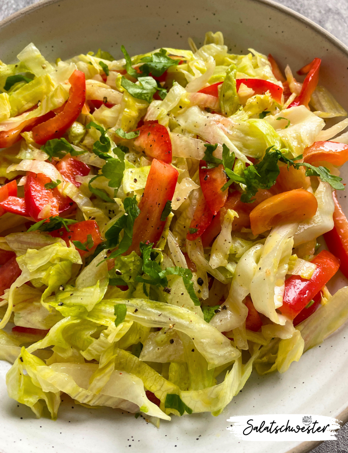 Nahaufnahme eines sommerlichen Paprika-Eisbergsalats mit würzigem Dressing – schnell und einfach zubereitet.