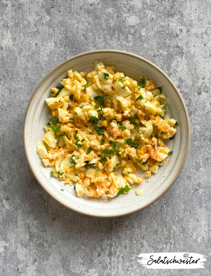 Frischer Eiersalat mit Zwiebeln und Öl, angerichtet als Beilage zum Abendbrot