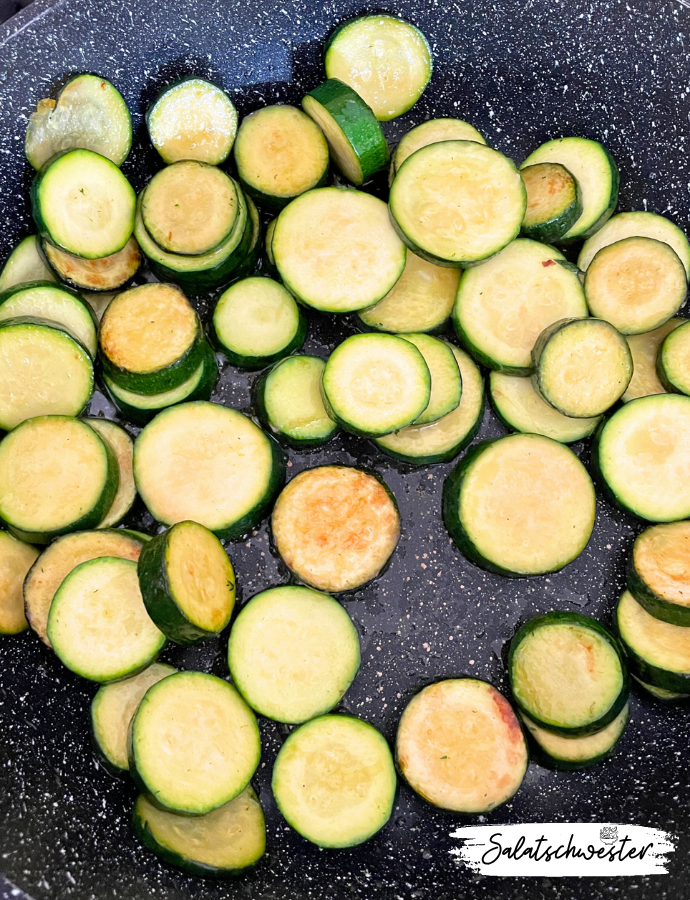 Frisch zubereiteter kalter Zucchinisalat mit Zwiebeln als gesunde, pflanzliche Beilage für Grillabende oder das Büro.