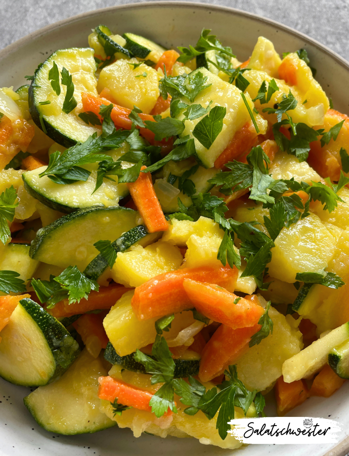 Vegetarischer Kartoffelsalat mit Zwiebeln, Zucchini und Möhren in frischer Vinaigrette.
