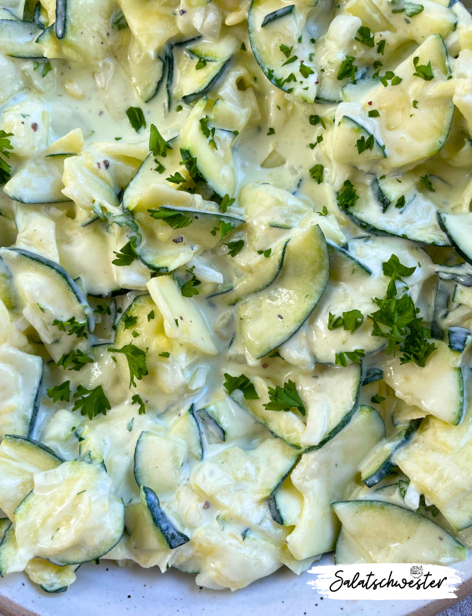 Cremiger Zucchinisalat mit saurer Sahne und frischen Kräutern serviert