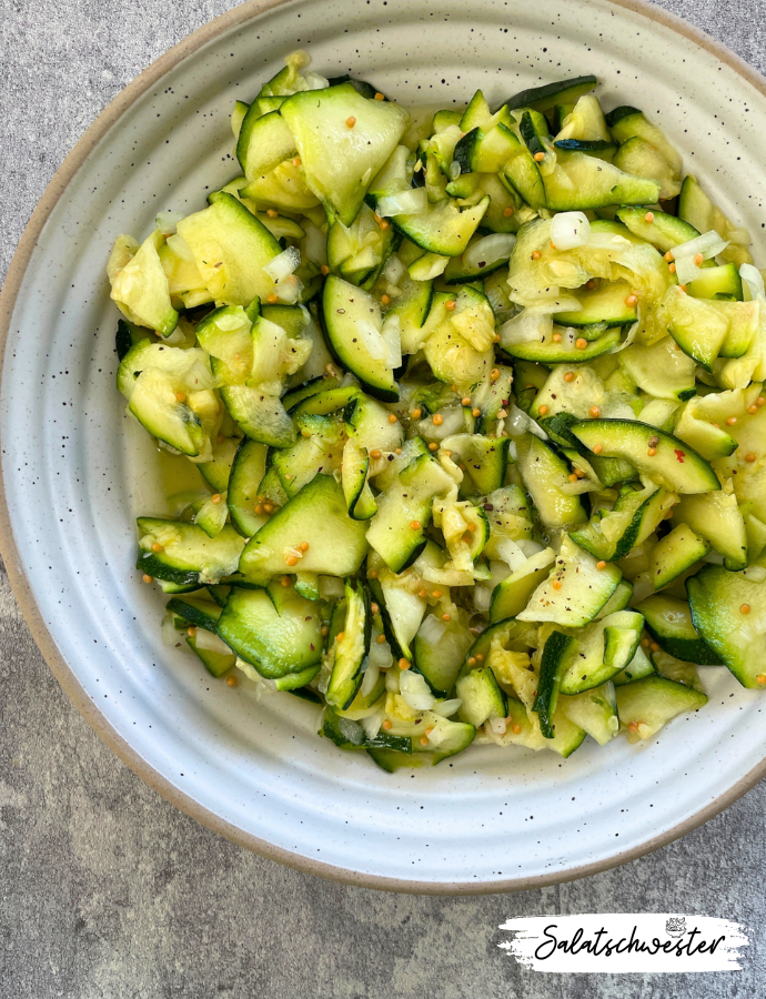 Knackiger Zucchinisalat mit süß-saurer Note, angerichtet auf Platte.