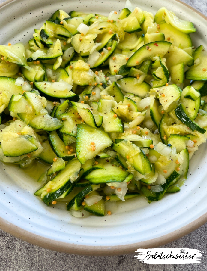 Hausgemachter Zucchinisalat süß-sauer mit Senfkörnern, servierfertig.