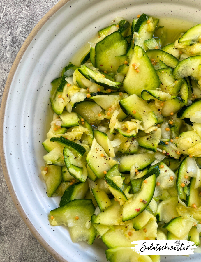 Knackiger Zucchinisalat mit süß-saurer Note, angerichtet auf Platte.