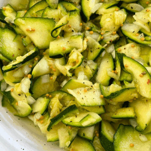 Leichter veganer Zucchinisalat mit Senfkörnern, Dill und Zwiebeln.