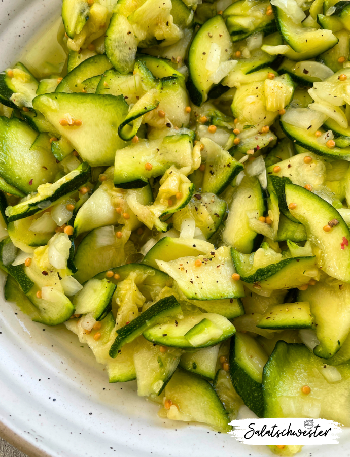 Leichter veganer Zucchinisalat mit Senfkörnern, Dill und Zwiebeln.
