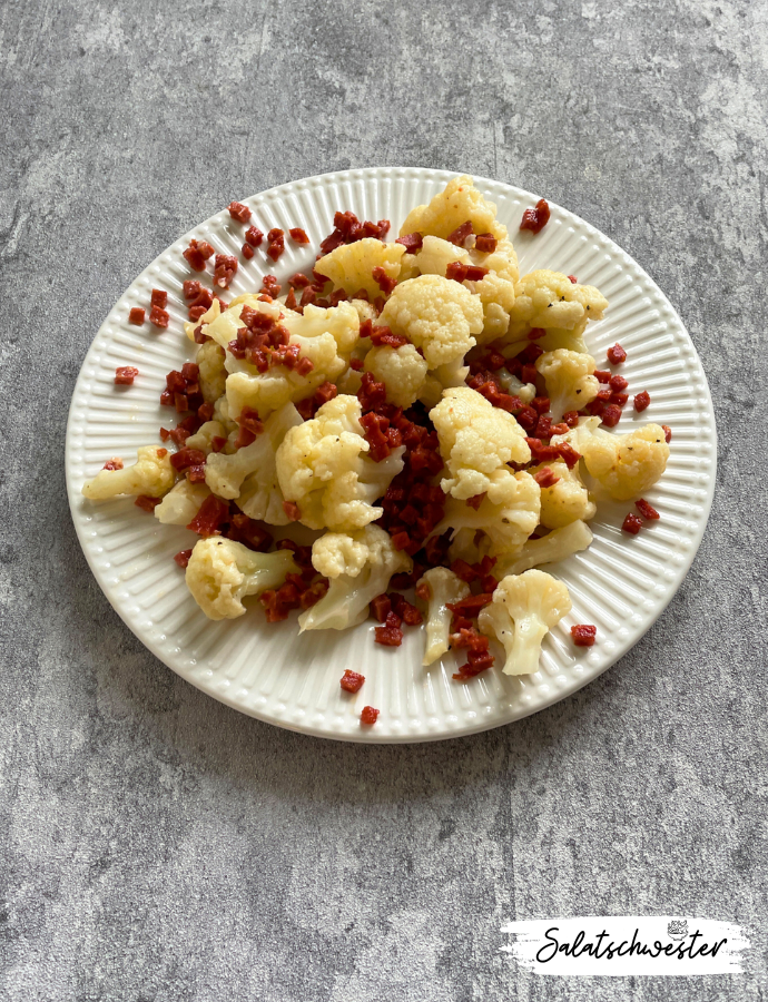 Herbstlicher Salat mit Blumenkohl, Dressing und veganem Schinken.