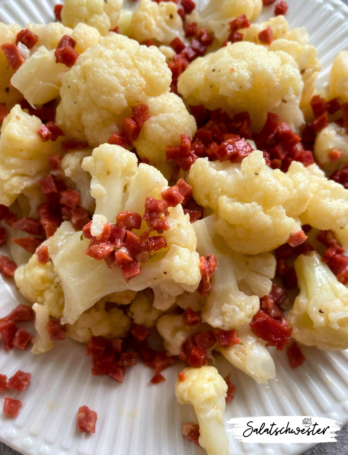 Veganer Blumenkohlsalat mit Schinkenwürfeln und Kräutern als Hauptgericht.