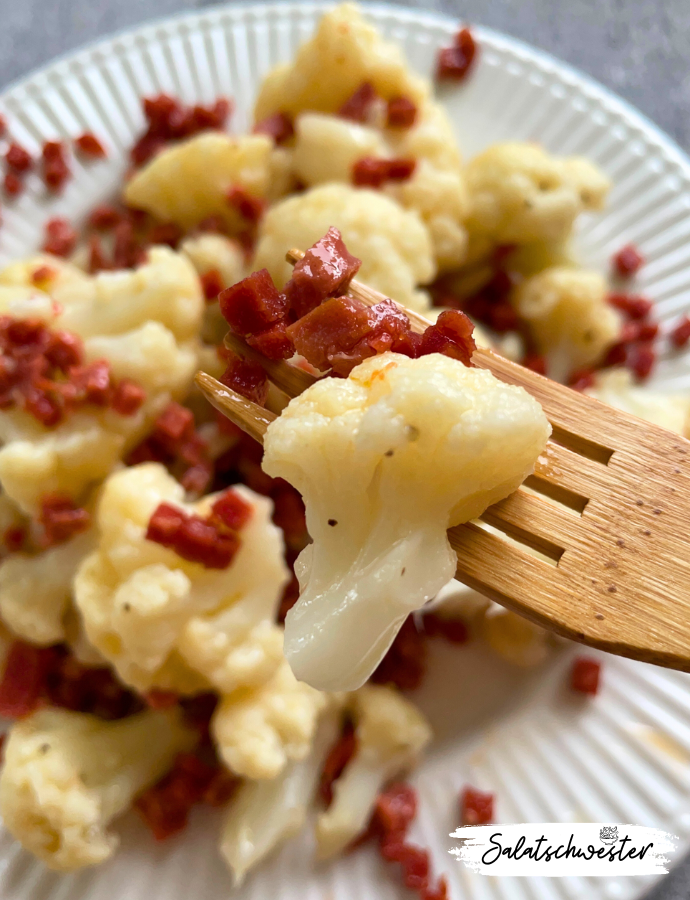 Warmer Blumenkohlsalat in Schüssel angerichtet, mit cremigem Essig-Öl-Dressing.