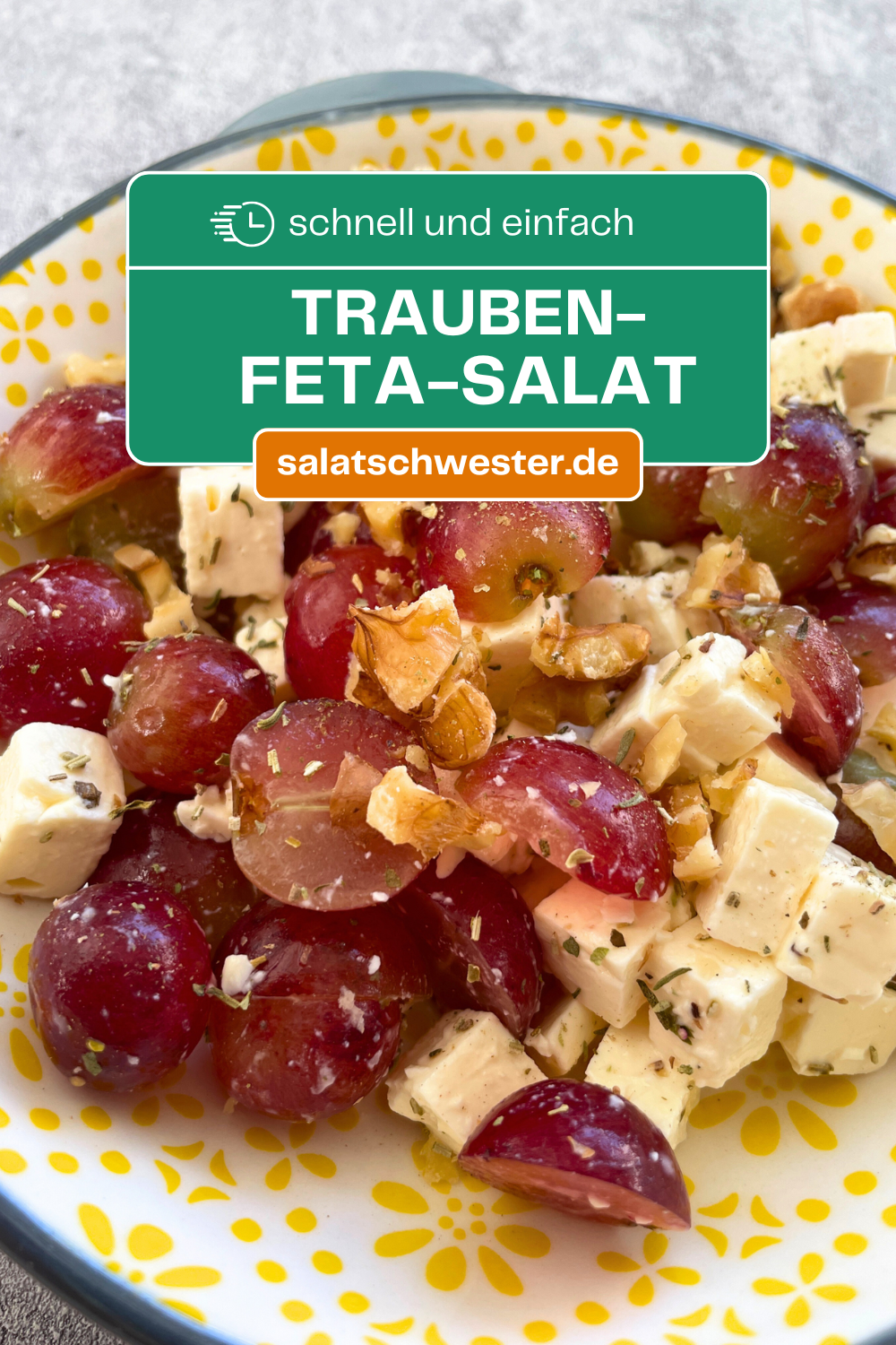 Frischer Trauben-Feta-Salat mit gehackten Walnüssen und Kräutern auf weißem Teller angerichtet